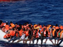 Farbfoto eines voll besetzten Fluchtbootes auf dem Mittelmeer