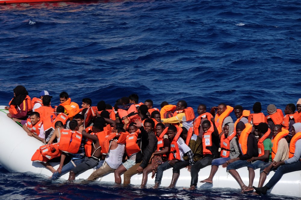 Farbfoto eines voll besetzten Fluchtbootes auf dem Mittelmeer