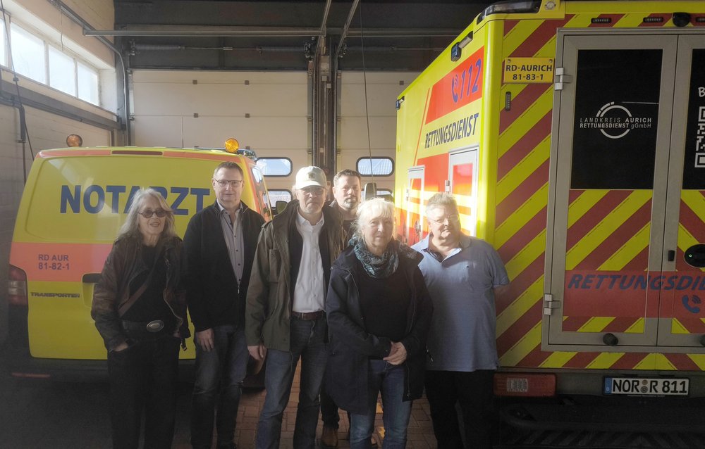Das Bild zeigt Gila Altmann, Carl-Heinz Arends, Thomas Ratmeyer, Marcel Schäfer, Angelika Albers, Gunnar Ott vor einem Rettungsfahrzeug.