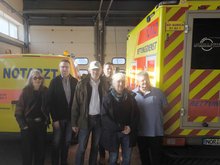 Das Bild zeigt Gila Altmann, Carl-Heinz Arends, Thomas Ratmeyer, Marcel Schäfer, Angelika Albers, Gunnar Ott vor einem Rettungsfahrzeug.